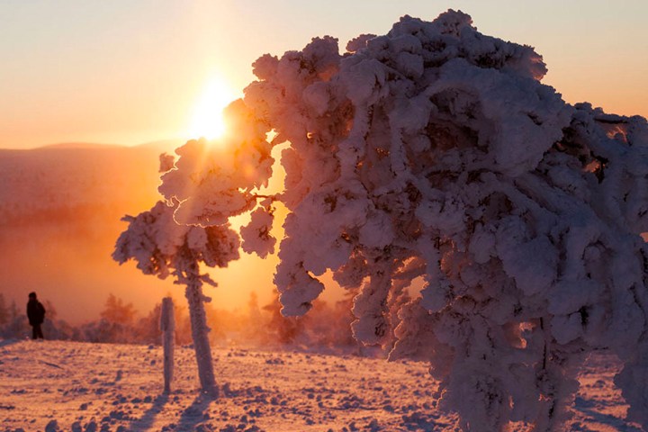 a sunset over a snowy field